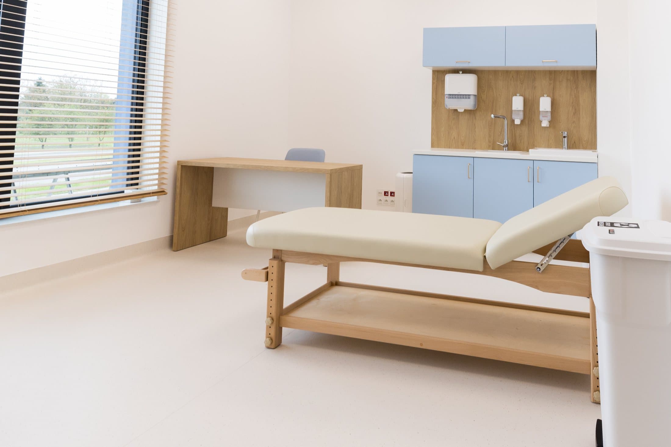 Jasny gabinet medical-space z leżanką i szafką medyczną